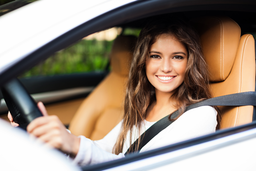 Smiling young woman in her car